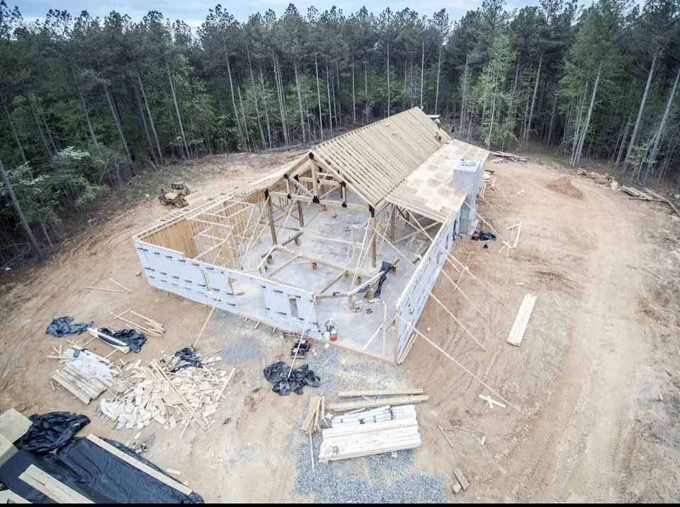 The barn’s timber frame going up on the cleared site in 2021