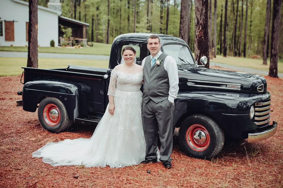 A bride and groom beside the farm’s black 1950 Ford pickup