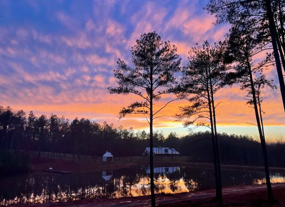 Pink and purple sky reflected in the farm lake