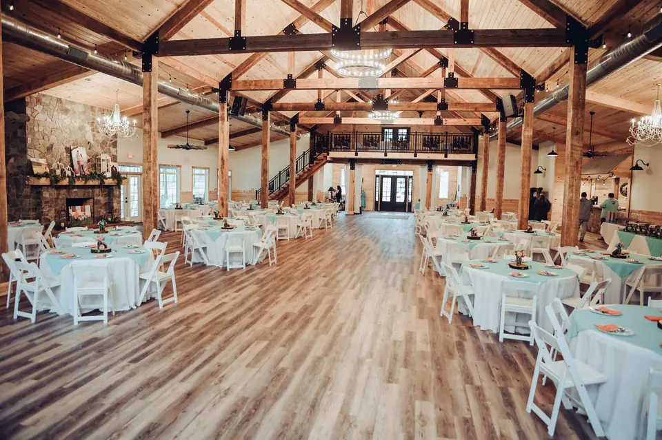 The reception hall set for dinner beneath exposed timber trusses
