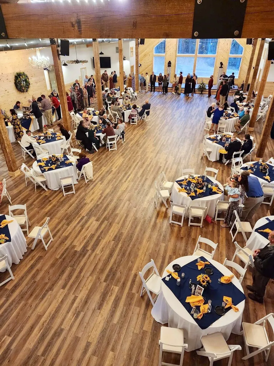 Guests at round tables during a party in the barn