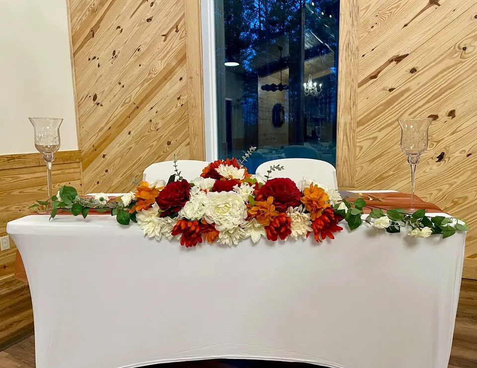 A sweetheart table with red and white flowers